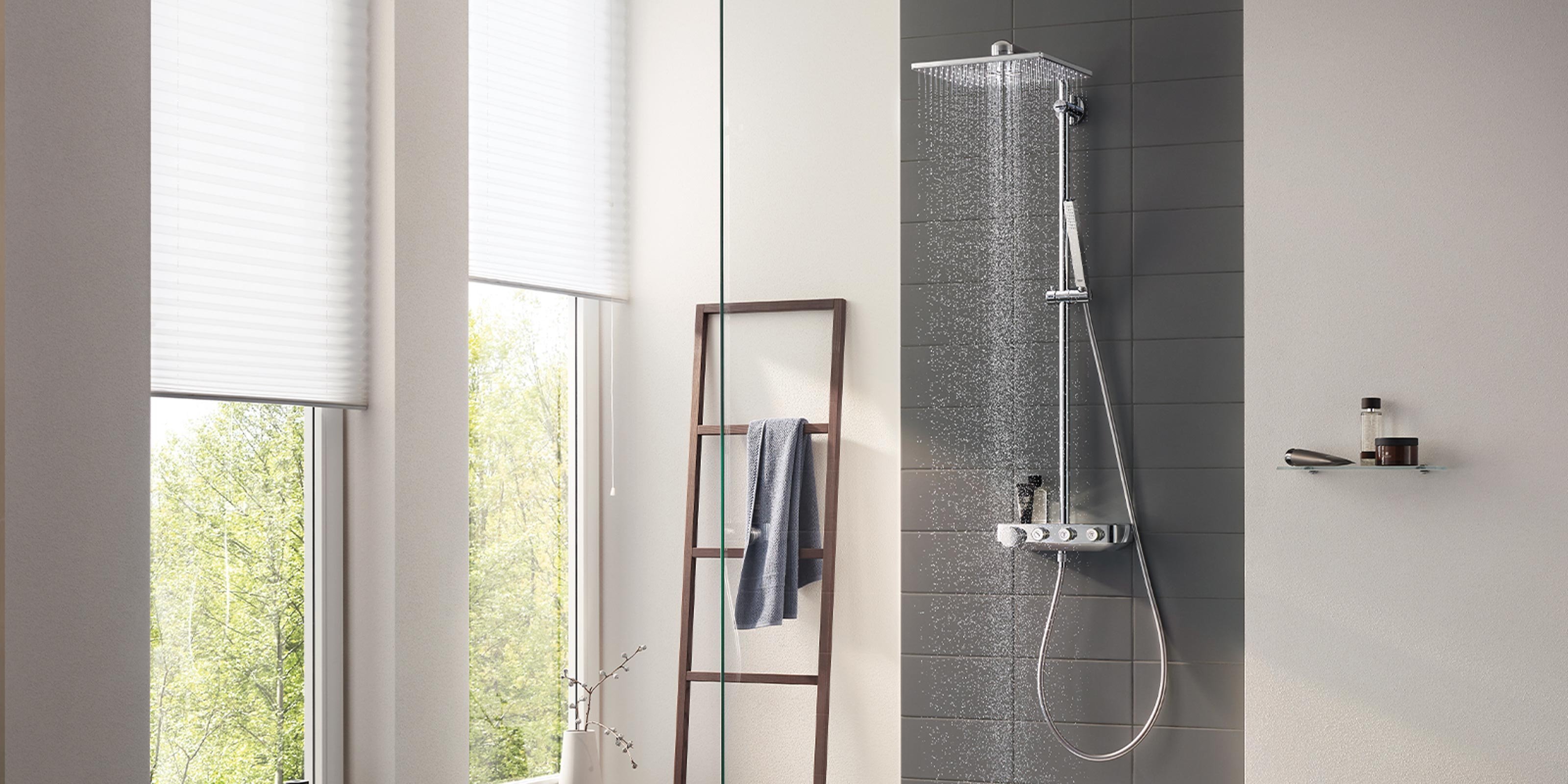 Ein modernes Badezimmer mit einer eleganten Dusche, die sanft Wasser sprüht, und großen Fenstern, die Tageslicht hereinlassen.