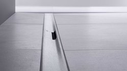 Ein schmaler Spalt in einem modernen Bodenbelag, der eine elegante Verbindung zwischen zwei Flächen schafft.