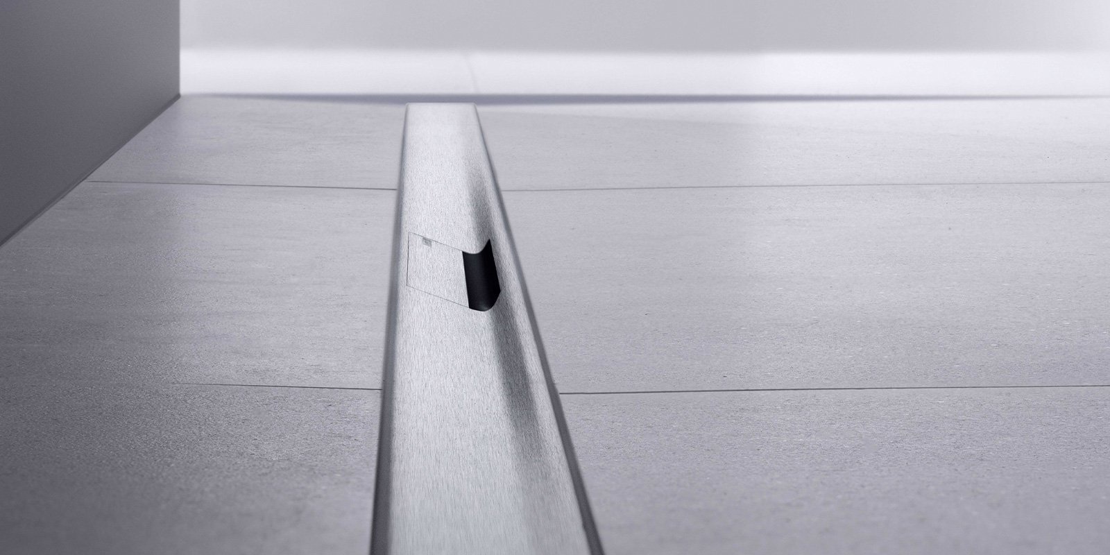 Ein schmaler Spalt in einem modernen Bodenbelag, der eine elegante Verbindung zwischen zwei Flächen schafft.