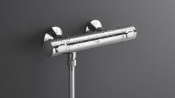 Ein glänzender, chromfarbener Duschthermostat mit Wassertropfen, montiert an einer grauen Wand.